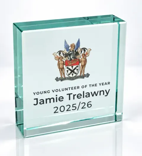 Small square glass award printed with a club crest and the wording Young Volunteer Of The Year, Jamie Trelawny, 2025/26