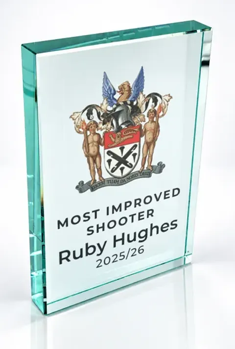 Large portrait glass award printed with a club crest and the wording Most Improved Shooter, Ruby Hughes, 2025/26