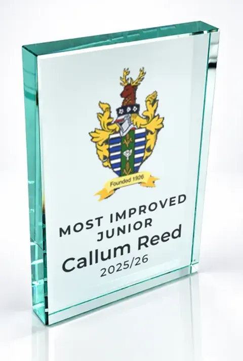 Large portrait glass award printed with a club crest and the wording Most Improved Junior, Callum Reed, 2025/26