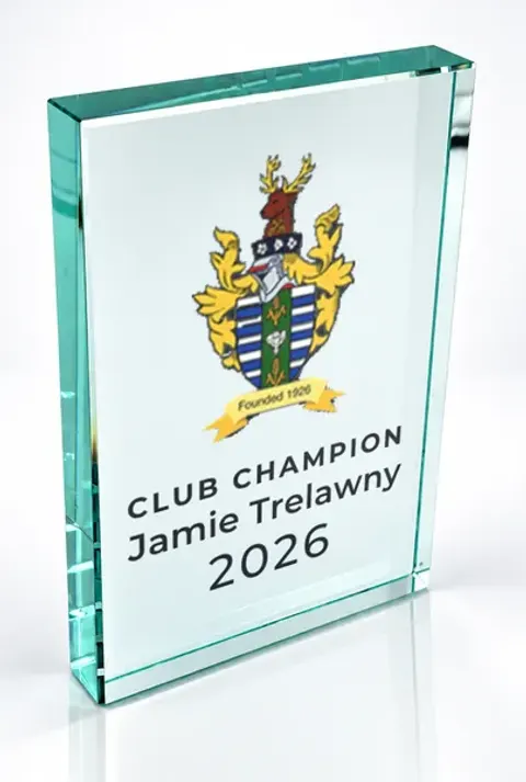 Large portrait glass award printed with a club crest and the wording Club Champion, Jamie Trelawny, 2026