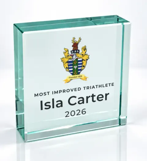 Small square glass award printed with a club crest and the wording Most Improved Triathlete, Isla Carter, 2026