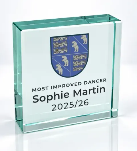 Small square glass award printed with a club crest and the wording Most Improved Dancer, Sophie Martin, 2025/26