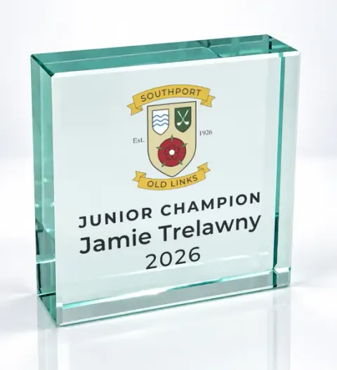 Small square glass award printed with a club crest and the wording Junior Champion, Jamie Trelawny, 2026