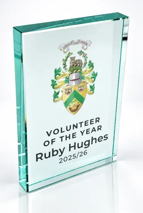 Large portrait glass award printed with a club crest and the wording Volunteer Of The Year, Ruby Hughes, 2025/26
